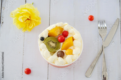 Close-up cream on a wooden table, kiwi, purple grapes, cherry tomatoes, top view