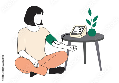 Woman checks her blood pressure at home with a digital monitor