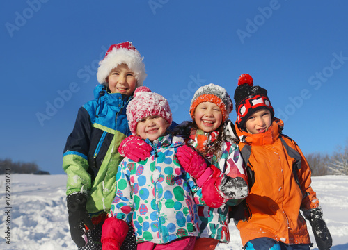 Group of children playing on snow in winter time