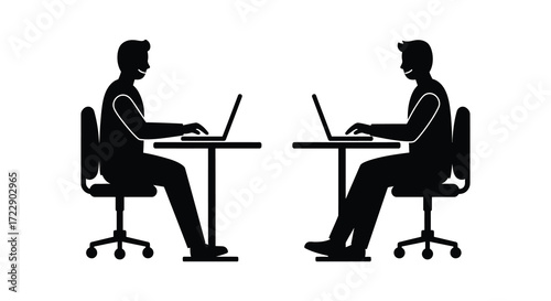 Two individuals working on laptops at desks facing each other