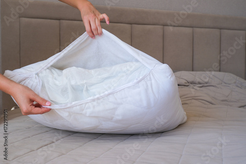 The woman removes the cover on the washing pillow. Change of bed linen.