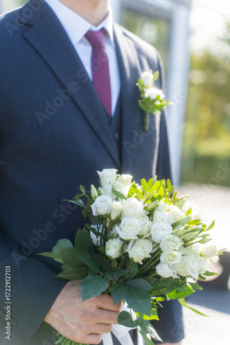 Close-up wedding couple bride and groom walk hand in hand through a pine forest, sunlight filtering through the trees