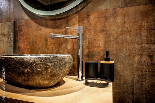 Luxury bathroom decor with handcrafted stone basin, chrome faucet, rustic wall surface, and wooden cabinet. Interior design blends modern comfort with spa-inspired elegance and serenity.