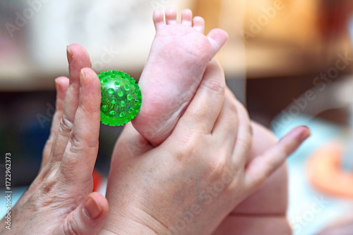 Wallpaper Mural Infant foot massage for sensory activity using a green spiked plastic Su Jok ball Torontodigital.ca