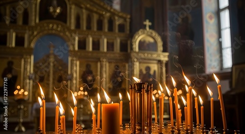Candles burning brightly in a dimly lit Orthodox church interior, creating a spiritual atmosphere.