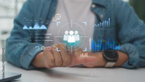 Fotografi Hand pointing at digital interface with target icon and data analytics graphs, representing customer targeting, data-driven strategy, and business intelligence technology