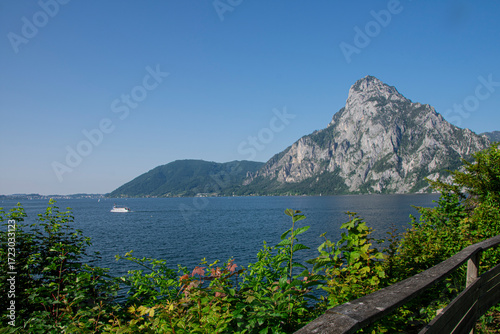 Scenic Traunsee lake with mountain view and boat floating on calm water