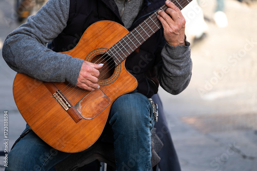 street artist, guitarist with classical guitar performs on the street