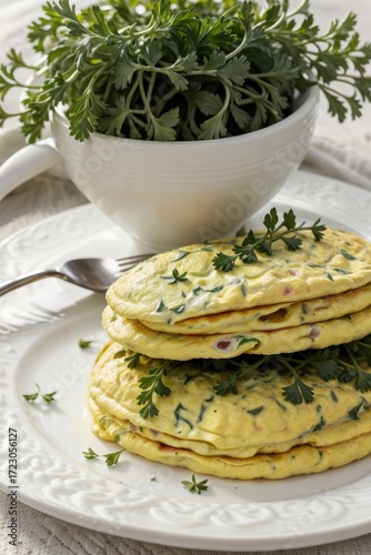 omelette with fresh parsley on a white plate closeup view breakfast dish served on table decorated with herbs bright natural light grey background concept of restaurant food blog cooking school