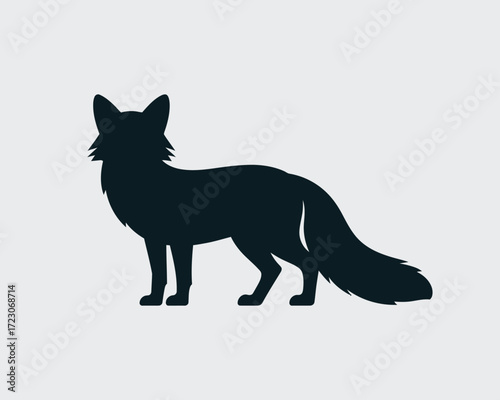 Silhouette of a standing fox with a bushy tail on a light background
