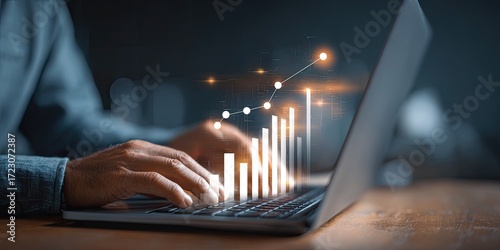 Close-up of hands typing on a laptop, with a graphic of increasing bar chart overlaid