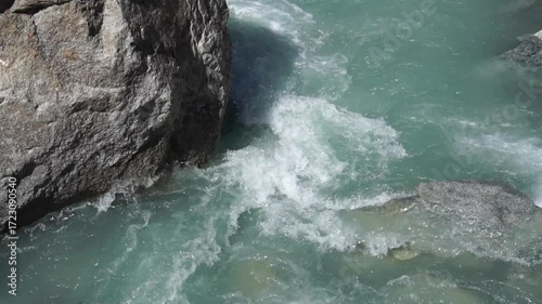 Slow motion flowing of Ala-Archa River carves through rocky mountain terrain. Steep cliffs and clear glacial water. Rafting, kayaking, canoeing, backpacking and daytrip adventure in wild landscapes.