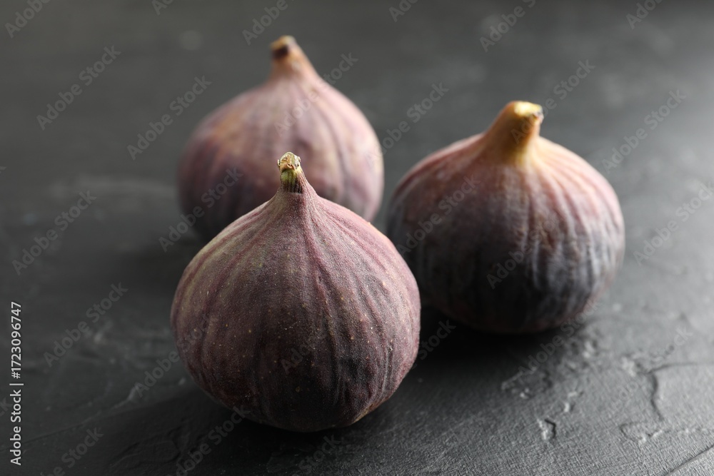 Obraz premium Fresh ripe figs on dark textured table, closeup