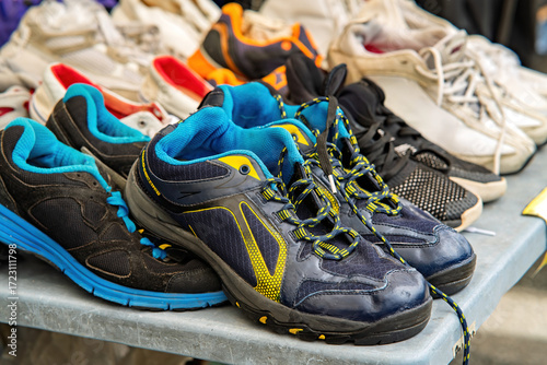 Used running sports shoes from various brands for sale at the market.