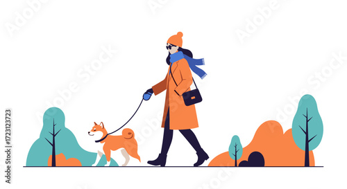 A person walks their dog in a park during autumn wearing warm clothes.
