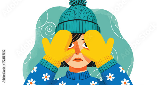 Worried woman covering eyes with cozy mittens in winter hat and floral sweater, feeling anxious about cold weather, seasonal depression concept