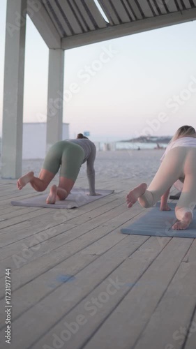 Women practice yoga on a serene deck, promoting relaxation and mindfulness