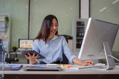 woman using mobile phone in modern office with laptop and digital tablet computer with VR icon diagram at office in morning light.
