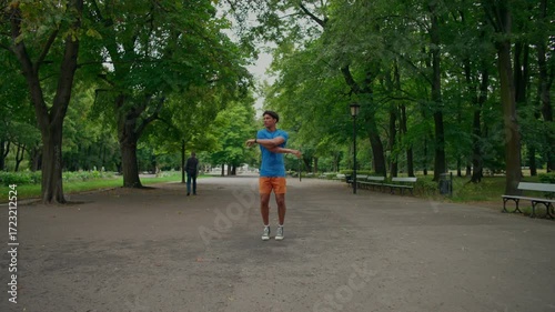 Wallpaper Mural A man does a warm-up before jogging in the park. A young athletic man exercises in the park in the morning. Torontodigital.ca