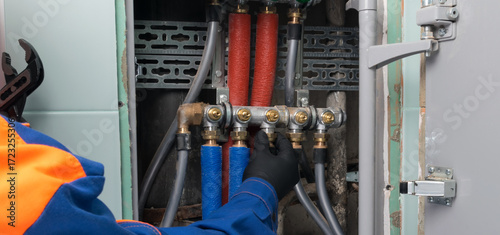 a plumber connects hot and cold water pipes by tightening the nut on the comb
