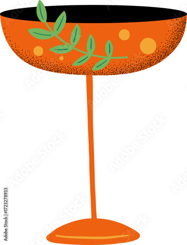 An orange cocktail glass with a sprig of greenery
