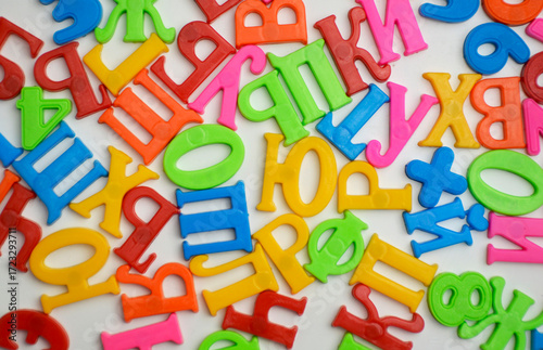 multi-colored plastic letters of Russian alphabets and numbers on a white magnetic board. teaching literacy, Russian language and mathematics at home in a playful way