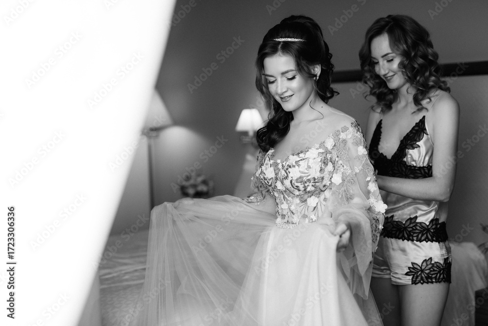 Fototapeta premium The bride and her bridesmaid getting ready in the morning of their wedding