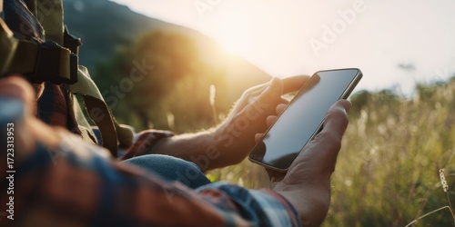 Man using smartphone connecting to nature at sunset