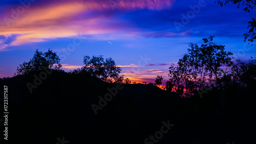 silhouette of trees and blue sky at sunset