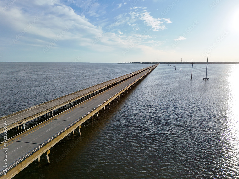 custom made wallpaper toronto digitalAerial view of a straight Wright Memorial bridge crossing a tranquil sea between Kill Devil Hills and Point Harbor toward the distant horizon. The sun glints off the water, creating a serene scene.