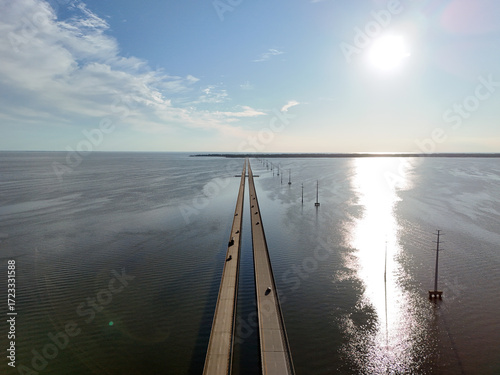 Wallpaper Mural Aerial view of a straight Wright Memorial bridge crossing a tranquil sea between Kill Devil Hills and Point Harbor toward the distant horizon. The sun glints off the water, creating a serene scene. Torontodigital.ca