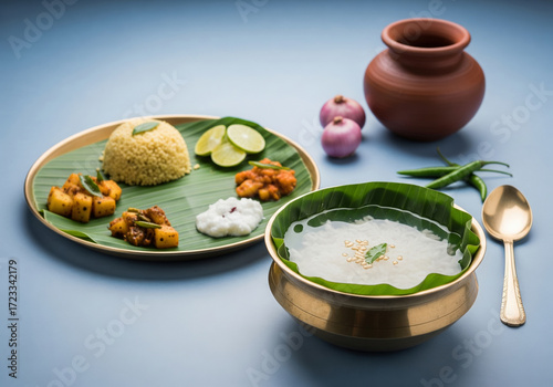 An appetizing Odia pakhala platter featuring fermented rice served with an array of traditional side dishes in beautiful brass bowls.