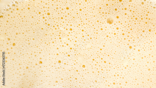 Effervescent, golden froth bubbles on creamy delight, evoking Champagne Day and lactic fermentation, mysterious microscopic carbonation dance