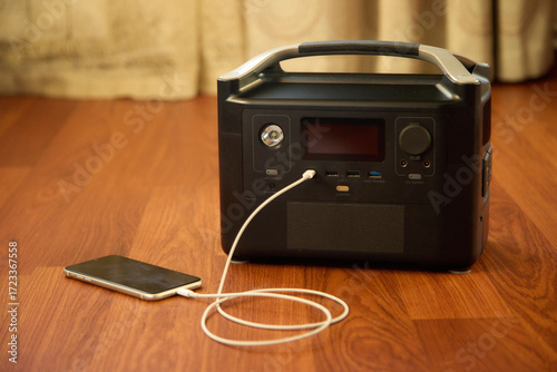 Portable power station charging a phone. Backup energy