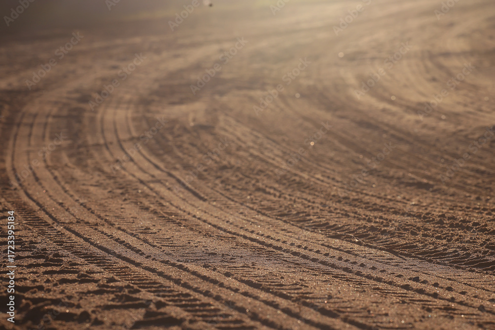 Naklejka premium tire tread marks on a clay road, abstract texture background
