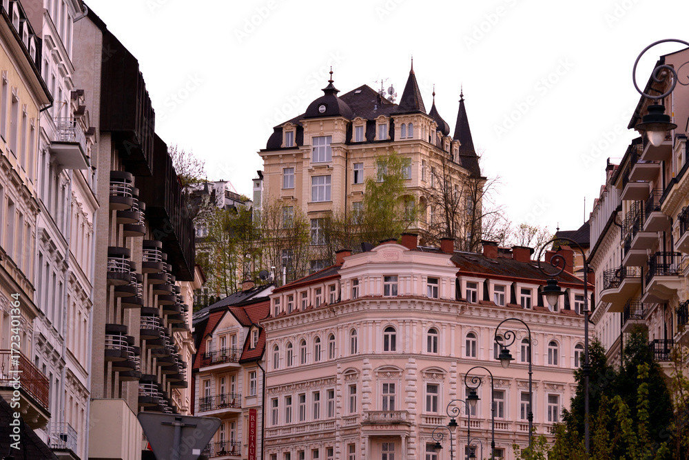Obraz premium This is a view of Karlovy Vary's streetscape, showing elegant, historical buildings with detailed facades and balconies. The architecture features a mix of styles