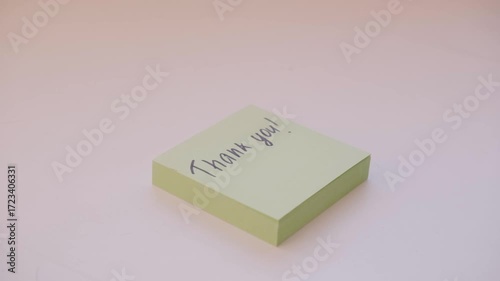 Hand peels off the sticker with the word Thank you.