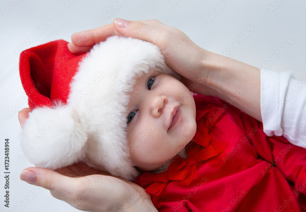Obraz premium Portrait of Christmas baby is lying on mother’s hands