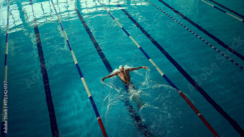 Foto Focused swimmer executing butterfly stroke in indoor lane with powerful energy