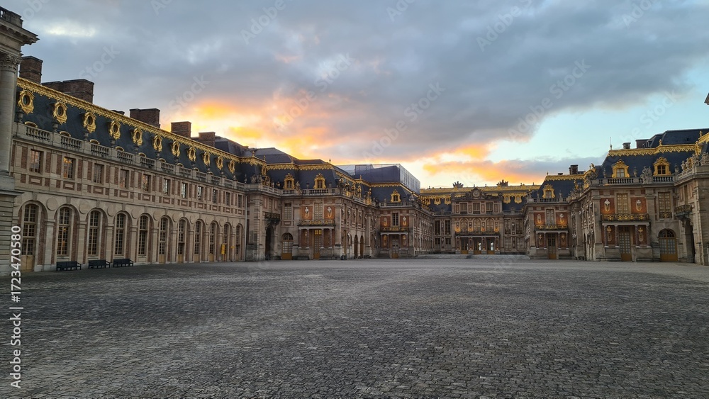 Obraz premium Le château de Versailles vu à travers le portail au coucher du soleil (Île-de-France)