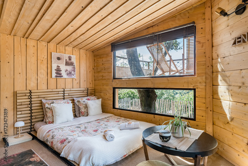 Foto intérieur de cabane zen en bois avec lit kingsize oreillers tables et bols