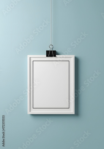 Minimalist hanging frame mockup using bulldog clip on pastel background with soft clean lighting
