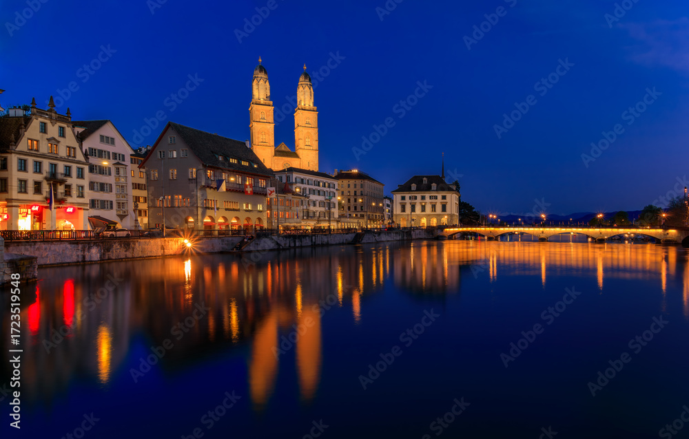 Fototapeta premium Cityscape with classic buildings on Limmat River in Altstadt Old Town and iconic Grossmunster Romanesque cathedral, Zurich, Switzerland at sunset