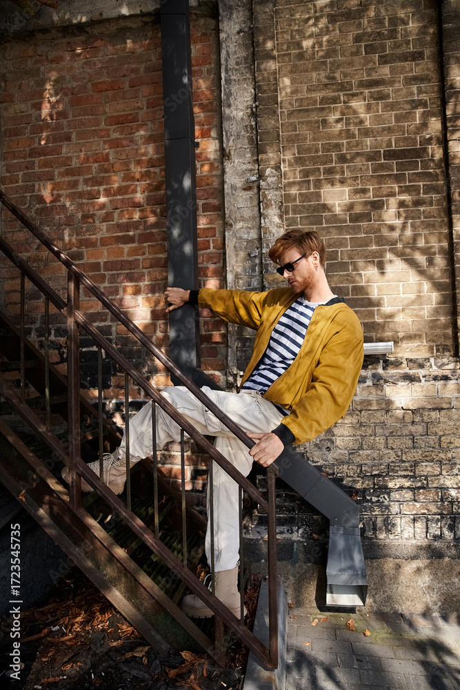 Fototapeta premium Stylish redhead man enjoying an autumn day in the city with trendy fashion choices