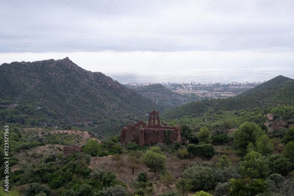 Fototapeta premium bandoned convent in Desert de les Palmes, with Benicàssim and the sea in the background, perfect for travel, history, and atmospheric landscape photography
