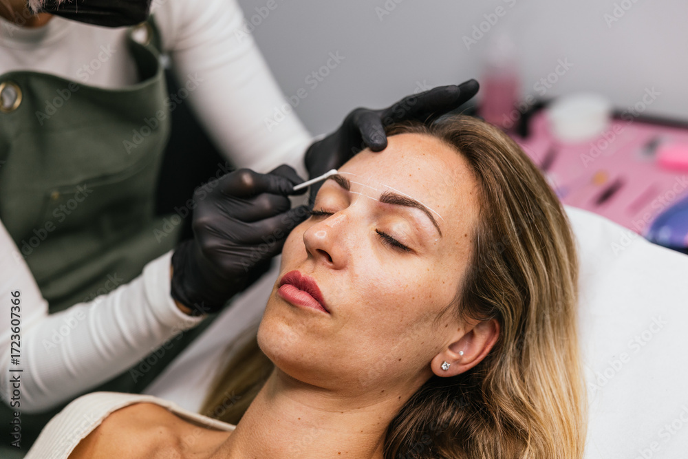 Naklejka premium Preparing for microblading, focused eyebrow design