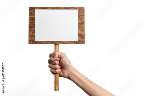 A hand holds a wooden sign with a blank white surface