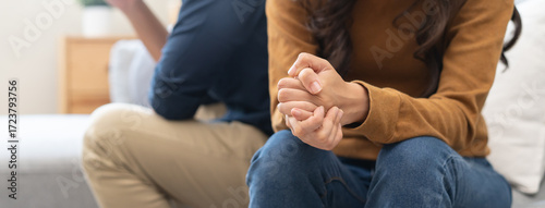 Family problem concept, Close-up hands of Asian wife sitting on sofa and husband sitting back to back in the living room at home have problems in a relationship and have an argument