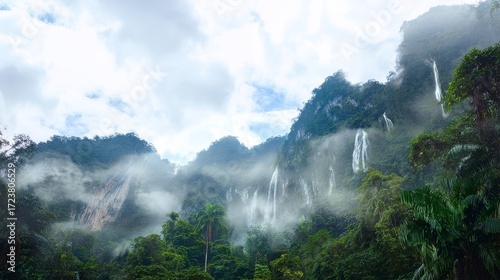 Fototapeta Naklejka Na Ścianę i Meble -  Tropical mountain jungle with waterfalls cascading down cliffs in misty atmosphere, high-resolution exotic wilderness landscape scene