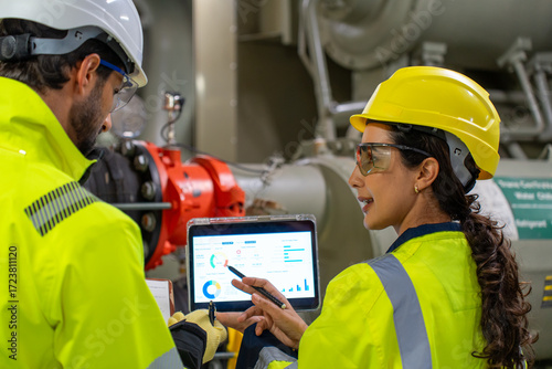 Tableau sur toile Industry professionals in helmets and uniforms collaborating over system control, pipeline, and ventilation for safety and project success
